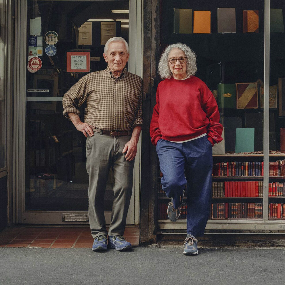 A man and woman standing on the street in front of a bookstore.